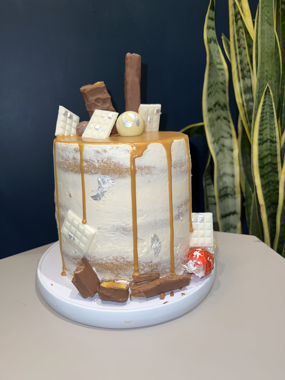 Semi-naked cake with caramel drip and chocolate bars